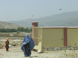 診療所の上空を飛ぶ軍用ヘリコプター