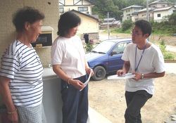 戸別訪問をして自宅生活者への聞き取りをする岩田（右）