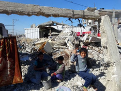 破壊された住宅跡に暮らす子どもたち。ガザ地区、15年3月