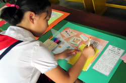 絵画交流で日本へ向けてメッセージを書く平壌の小学生