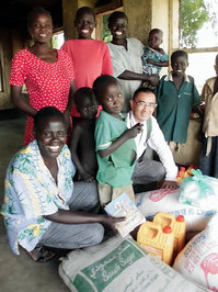 食料配布を受け取った人々と、支援を担当したスーダン事業現地代表の今井（前列右）