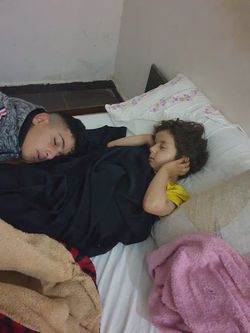 空爆の合間、つかの間の睡眠をとるアマルさん（パートナー団体スタッフ）の息子さんとお孫さん。 耳をふさいだまま眠りに落ちています