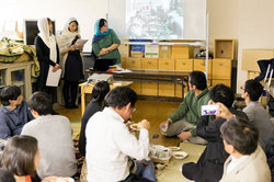 アフガン流に絨毯に座って食事を囲む