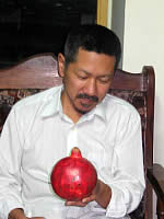 真っ赤なざくろを見つめる本間調整員