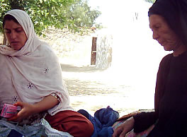 村の伝統産婆さんと配布した出産介助キットの確認をしているワグマ（写真左）