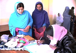 キットを配布の記録をつける診療所の助産師（右）