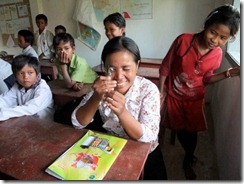 ルーペで草を観察する先生。子どもたちより興味津々？