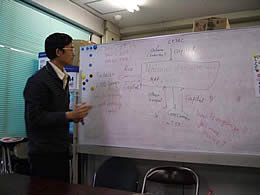 農民と消費者がCEDACを通じて現在どうつながっているのか図解して説明するコマさん