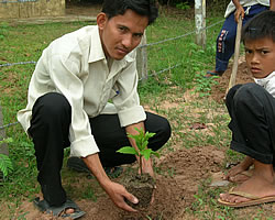 生徒とカシューナッツの苗木を植えるチャンソクニアン先生（25才）