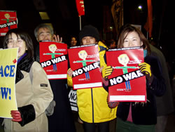 「No War」ポスターをもってデモに参加する人たち