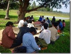 大規模に養殖を営む村人から話を聞く参加者たち