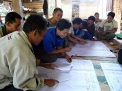 利用林に残る樹木を調べ、数値を確認し合う村人