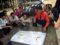 話し合いながら村の地図を描く村人