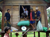 米銀行用の米倉の前で米を量る村人