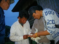 鶏にワクチンを投与する研修参加者