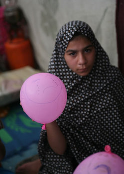 風船に泣き顔を描く女の子（この子の目の前で父親と弟が殺された）