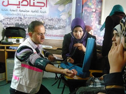 血圧の測定方法を教える医師（左）と、トレーニングを受ける参加者（右）。 参加者の一部はさらに専門的な救急法を学び、ボランティアとして東エルサレム各地で負傷者や病人の手当てを行っています。