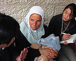フセイン病院で昨日出産した母親から話しを聞く看護師