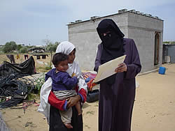 食料支援を受けた家庭を訪問、子どもの体重の変化を説明するクリニックの代表、母親の貧血も改善