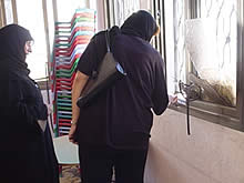 写真2:幼稚園の被害を確認する栄養改善事業の責任者(右）と幼稚園の先生(左)。銃弾は金属製の窓枠も貫通した。写真1と同じ教室。（2004年10月19日）