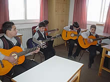 新しいギターで練習中の子どもたち