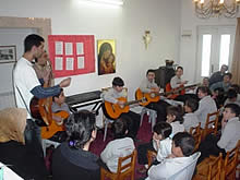 先生と一緒にギターで伴奏する子どもたち。キーボードでリズムも入って曲らしく聞こえるようになってきました。