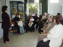 YWCAの研修室で、代表からの説明を熱心に聞き入る女性たち