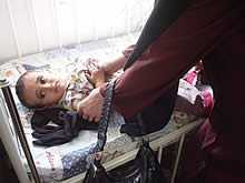 正確な身体計測のために、母親は子どもの服を脱がせます。