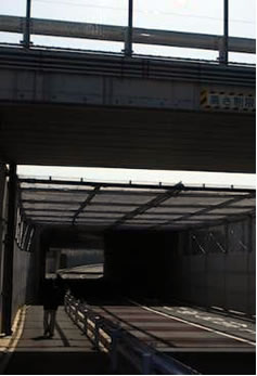 東峰に向かう道は高いフェンスで囲まれ、上には滑走路への迂回路が走る。