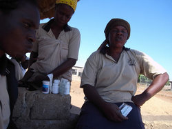 使用期限切れの薬を横に、患者に話しをするボランティア