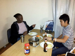 引っ越し直後。まだテーブル もないので、オフィス机といす、ひとりは脚立に座ってのでご飯 