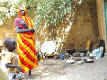 避難民の女性と屋外の調理場。調理器具は援助団体から支給された