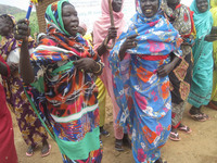 華やかな衣装と飾りのついたステッキを振って歌う