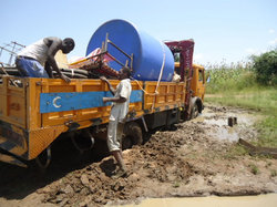 給水タンクなどの資材を乗せたトラックは、泥道にはまって立ち往生