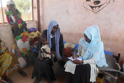 JVCが建設した幼稚園に避難している女性に聞き取りをするスタッフのサラ(写真右)