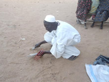 配布された農具で土を掘って「品質確認」をする人も