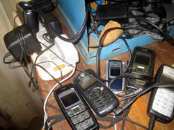 整備工場のコンセントでちゃっかり充電中のスタッフ・研修生の携帯電話