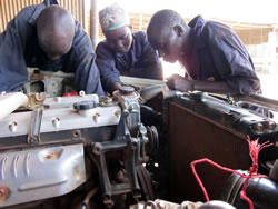 ラジエーターの修理について学ぶ新しい研修生たち 