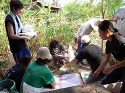 アヒルを捌くのを手伝う根本（右）