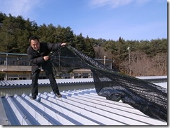 仮設住宅の屋上に遮光ネットを設置するJVC山崎