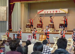 全児童による「小々汐太鼓」の披露 壇上の太鼓はJVCの呼びかけにより寄贈されたもの 