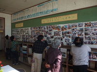 家族や知人が写った写真を眺める住民