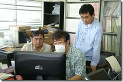持参したＨＤの活用法を、災害ＦＭのボランティアに説明する日比野さん（中央）
