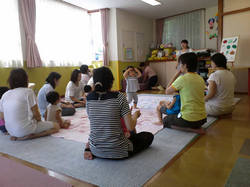 ②子育て支援センターでお遊戯をするお母さんと子どもたち