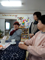 テーブルを囲んでパッチワークの縫い方を話すサロン利用者と道中内さん（真ん中）