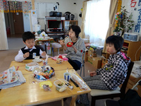 お昼の時間にやってくる子どもたちと話す藤さん（真ん中）
