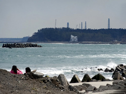 浪江町の海岸の向こう姿を見せる福島第一原子力発電所