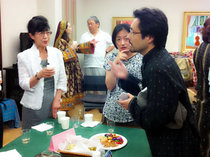 ワインやお菓子を囲んで参加者と交流するスタッフ小野山(右)