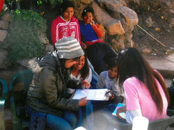 羊について聞くなら、世話をしている子どもが一番！ ニット帽をかぶって聞きとりをしているのが加藤さん