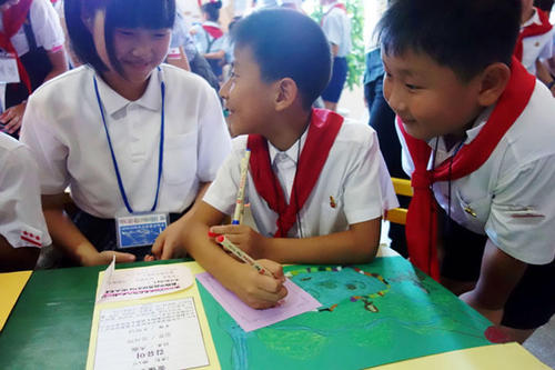 日本からの絵を前に談笑する平壌の小学生
